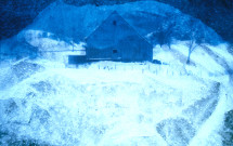 Double-exposed photo snow on plastic with barn